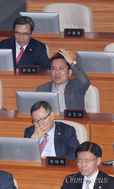 김진태, 홍영표 연설에 "내로남불" '5.18 망언'의 당사자인 김진태 자유한국당 의원이, 전두환씨가 광주 법정으로 향한 11일 오전 국회 본회의장에서 홍영표 더불어민주당 원내대표의 교섭단체 대표연설을 들으며 "내로남불'이라고 내뱉고 있다. 같은 당 이종명 의원은 이날 본회의에도 불참해 자리가 비어 있다.  