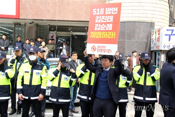  김선경 청년민중당 대표가 3월 11일 자유한국당 경남도당 앞에서 손팻말을 들고 서 있다.