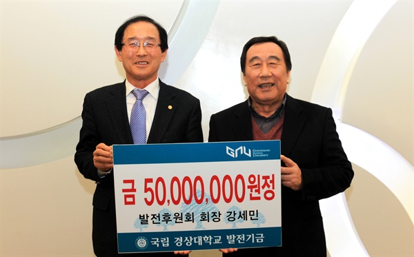 강세민(오른쪽) 경상대학교 발전후원회장이 이상경 총장에게 발전기금 5000만 원을 전달한 뒤 기념촬영하고 있다.