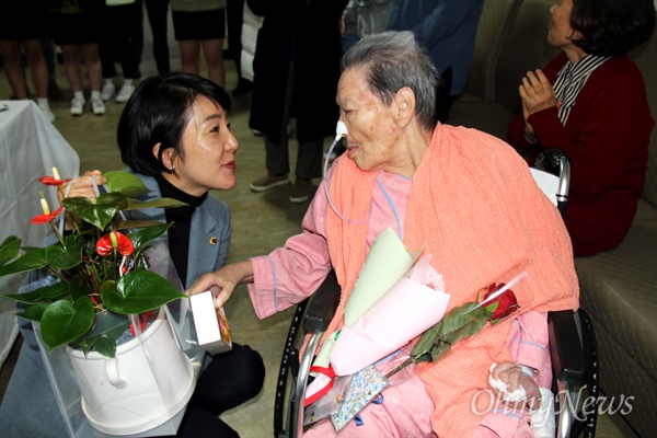  일본군위안부 할머니와 함께하는 마산창원진해시민모임은 3월 13일 오후 마산우리요양병원에서 김양주 할머니 생일잔치를 열었고, 김지수 경남도의회 의장이 화분을 선물하며 손을 잡고 있다.