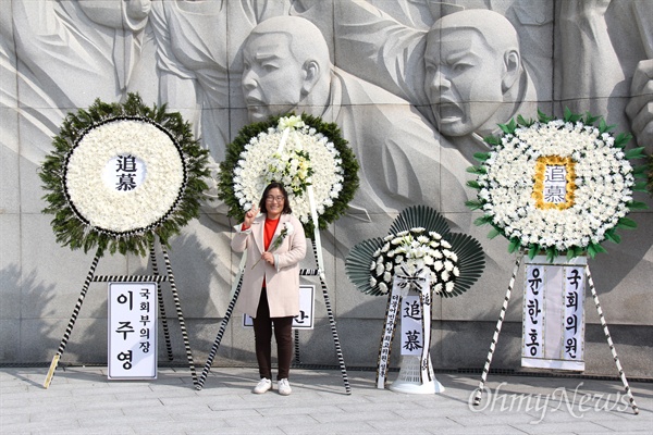 국립 3.15민주묘지에 놓여진 황교안 자유한국당 대표의 조화 앞에 한 사람이 가리고 서 있다.