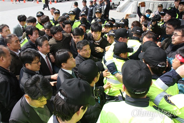 3월 15일 오후 '대우조선해양 매각반대, 지역경제살리기 경남대책위원회'가 경남도청 현관 앞에서 대화를 요구하며 손팻말을 들고 서 있는 가운데, 정승일 산업통상자원부 차관이 간담회 참석을 위해 차량에서 내려 경찰의 보호를 받으며 경남도청 안으로 들어가고 있다.