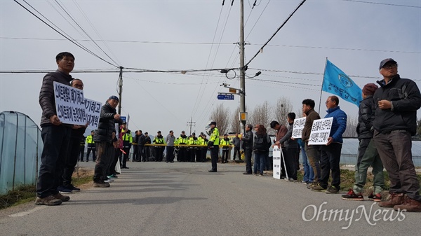 농림축산식품부 '스마트팜 밸리사업 현지실사단'이 3월 18일 오전 밀양 임천리 일대에서 현장실사를 벌이자, 농민들이 중단을 요구하며 손팻말을 들고 서 있다.
