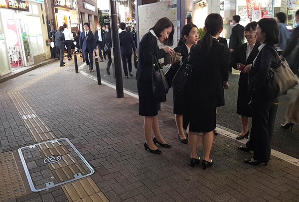 도쿄의 한 번화가에서 여자 대학생들이 이야기하고 있다.