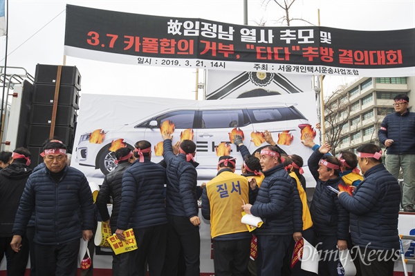 21일 오후 서울 광화문 KT앞에서 서울개인택시운송사업조합 주최로 열린 '3.7카풀 합의 거부, '타다' 추방 결의대회'에서 참가자들이 '타다' 화형식을 하고 있다.