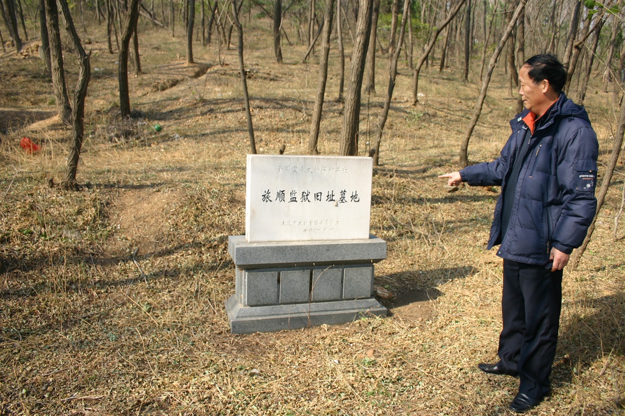 다롄안중근연구소 박용근 회장이 뤼순감옥 묘지를 가리키고 있다.