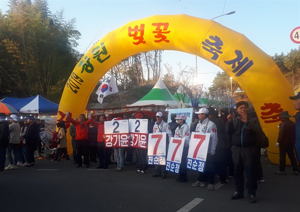 강기윤 자유한국당 후보 선거운동원과 진순정 대한애국당 후보 선거운동원들이 31일 창원 교육단지 벚꽃축제 행사장 정문 앞에서 유세전을 이어가고 있다. 