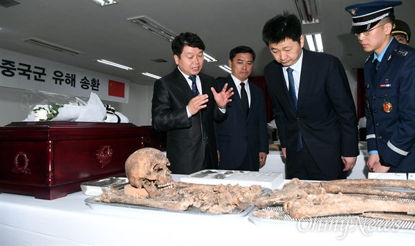 한국 유해발굴감식단과 중국 퇴역군인사무부 실무단을 포함한 양측 관계자들이 입관에 앞서 유해를 둘러보고 있다.