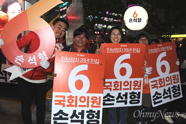 4.3 창원성산 국회의원 보궐선거에 나선 민중당 손석형 후보의 선거운동원들이 4월 2일 저녁 창원 상남동 분수광장에서 손팻말을 들고 서 있다.