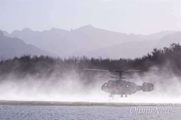 5일 오후 강원도 고성의 한 저수지에서 전날 부터 시작된 산불을 진압하기 위해 소방 헬기가 물을 보충하고 있다. 