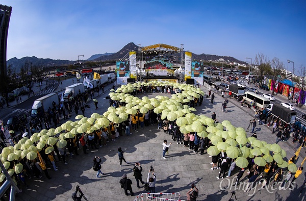 세월호참사 5주기를 앞 둔 13일 오후 서울 광화문광장에서 대학생들과 시민들이 우산을 펼쳐 세월호 기억 리본을 만드는 플래시몹을 하고 있다.