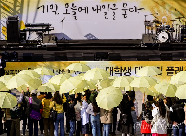 세월호참사 5주기를 앞 둔 13일 오후 서울 광화문광장에서 대학생들과 시민들이 우산을 펼쳐 세월호 기억 리본을 만드는 플래시몹을 하고 있다.