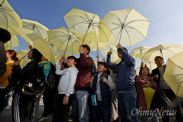 세월호참사 5주기를 앞 둔 13일 오후 서울 광화문광장에서 대학생들과 시민들이 우산을 펼쳐 세월호 기억 리본을 만드는 플래시몹을 하고 있다.