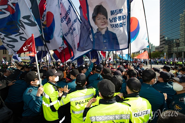 지난 13일 오후 서울 세종로 네거리에서 박근혜 석방 요구 집회에 참가한 대한애국당원들이 행진 도중 경찰과 몸싸움을 벌이고 있다.