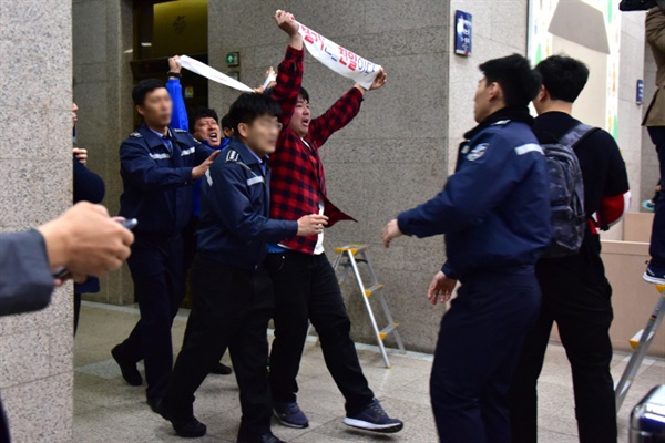 시장실 앞 점거 농성 중 끌려 나오는 민주노총 부산본부 이우백 통일위원장(왼쪽)