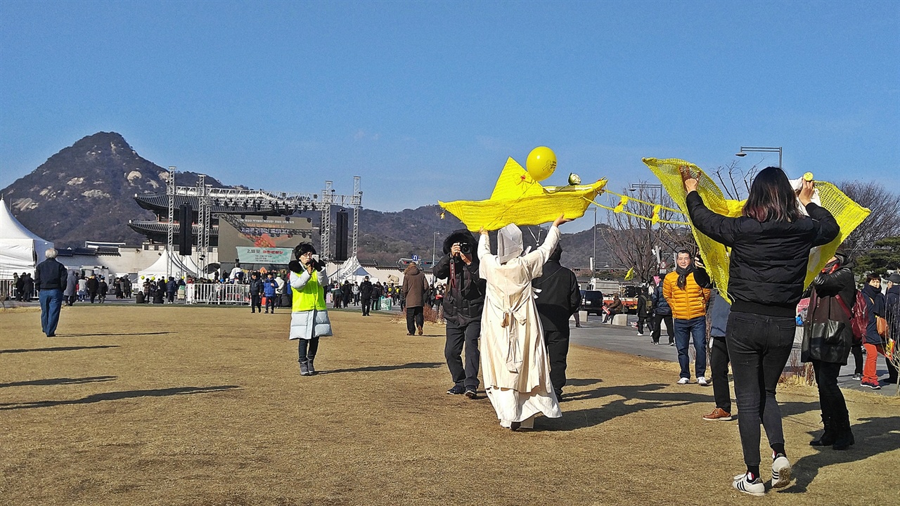 세월호를 상징하는 노란색 배가 무명천을 가르고 광장으로 나가자 그 뒤를 나비가 따른다.