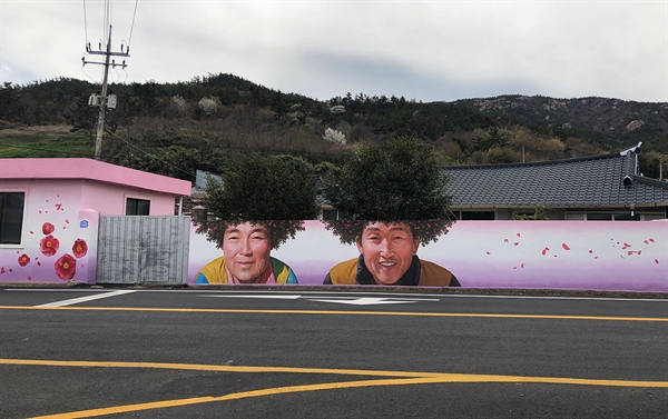 애기동백꽃을 배경으로 한 이 마을벽화는 전남 신안군이 고향인 김지안 작가가 신안군의 제안을 받아 작업했다.