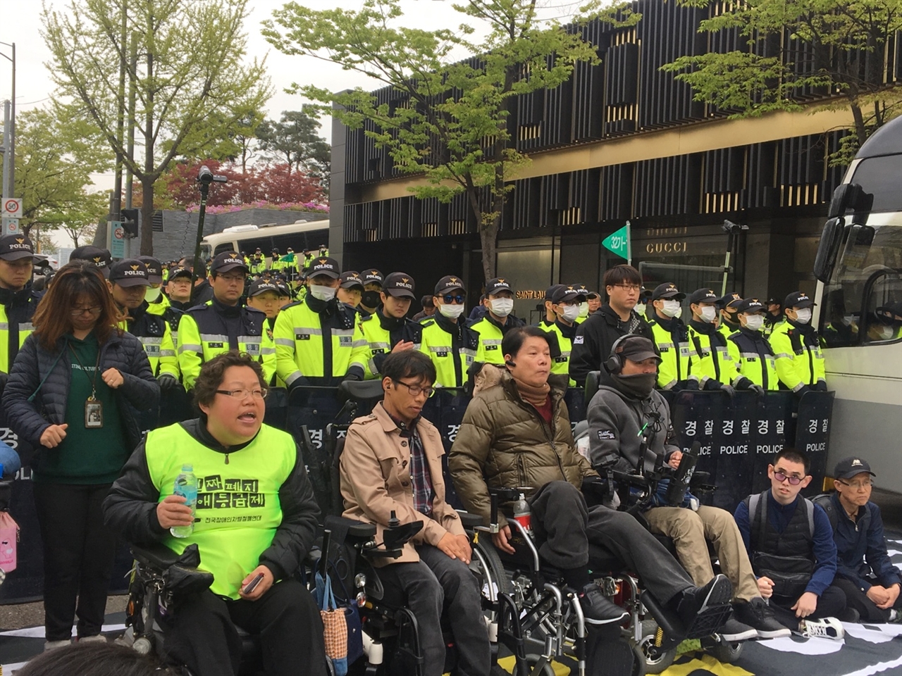 18일 오전, 63빌딩에서 열린 '장애인의 날 기념식'에 입장 저지를 받은 장애인 단체 회원들이 이를 규탄하며 도로 점거 및 농성을 이어가고 있다.