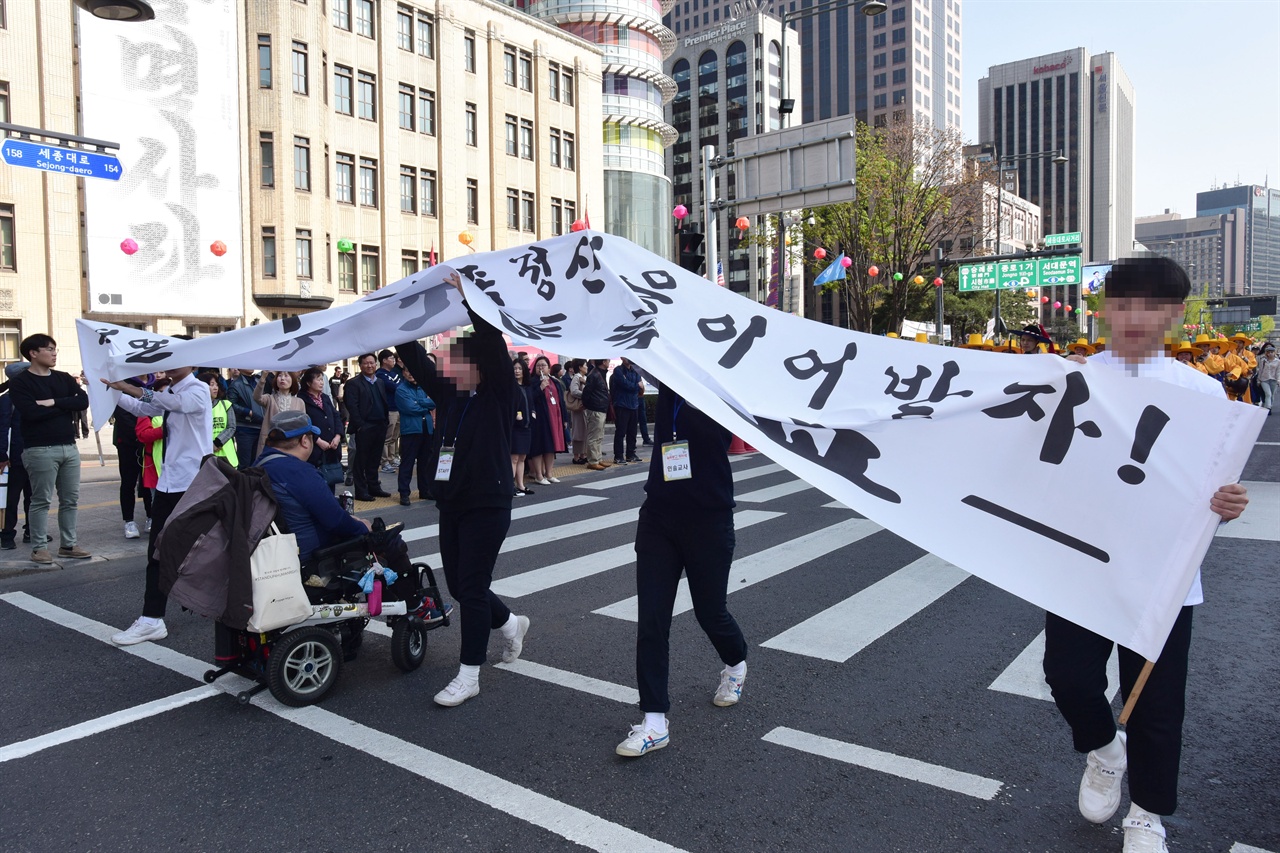  19일 오후？‘420 장애인 차별 철폐의날 행진’ 참가자들이 서울 세종로 세종대로 사거리를 점거한채 ‘장애등급제 폐지”를 요구하며 농성을 벌이자  '419혁명 대행진'을 벌이던 참가자들이 펼쳤던 현수막을 높이 들어 행진을 하고있다. 2019.4.19