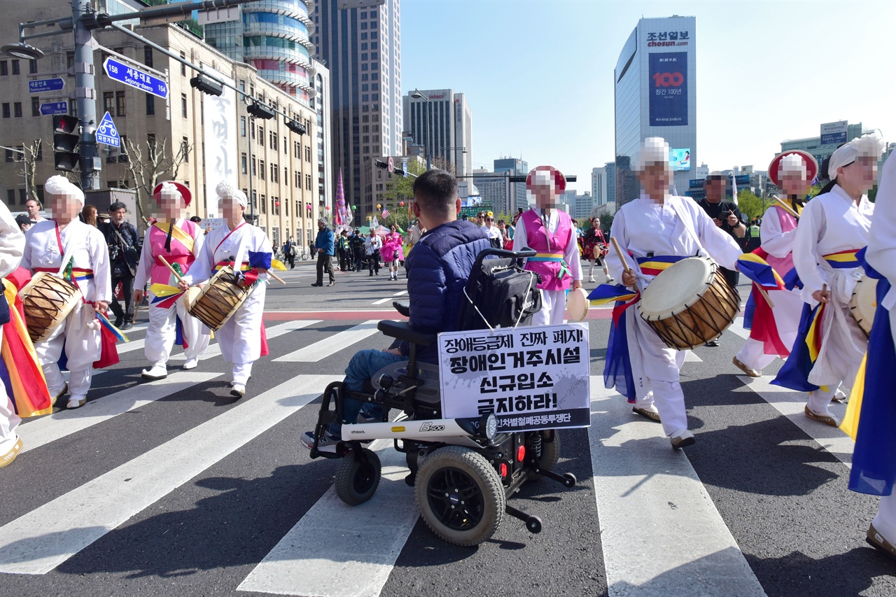  19일 오후？‘420 장애인 차별 철폐의날 행진’ 참가자들이 서울 세종로 세종대로 사거리를 점거한채 ‘장애등급제 폐지”를 요구하며 농성을 벌이자  '419혁명 대행진'을 벌이던 참가자들이 농성자를 비켜서 행진을 하고있다. 2019.4.19