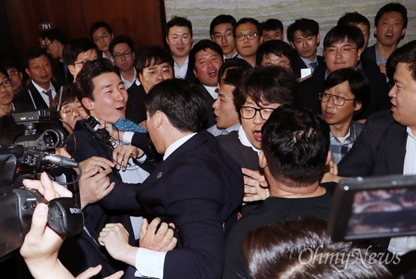 국회 경위 끌어내는 한국당 지난 26일 새벽 경호권이 발동된 국회 본관 의안과 앞에 국회 경위들이 도착하자, 자유한국당 의원 보좌진 및 당직자들이 이들을 한 명씩 끌어내고 있다.