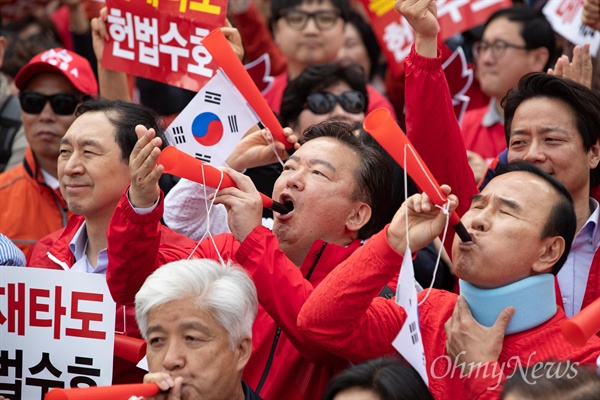 자유한국당 민경욱 의원이 지난 4월 27일 오후 서울 세종문화회관앞에서 열린 문재인 정권 규탄집회에서 부부젤라를 불고 있다. 오른쪽은 박덕흠 의원.