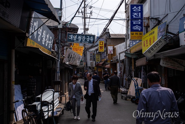  을지로 세운공구상가는 시간이 얽혀 있다. 30년 이상된 붓글씨 낡은 간판과 현대식 간판이 공존하고 젊은 작업자는 자신보다 나이가 많은 기계를 조작한다. 골목 너머로 서울타워가 미세먼지 속에 슬며시 모습을 드러내고 있다.