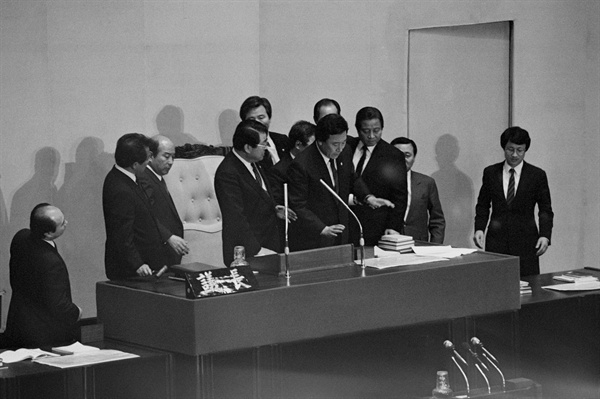 1988년 3월 8일, 국회 본회의에서 민정당 의원들과 경위들이 야당 의원들의 접근을 차단한 가운데 장성만 부의장이 선거법 개정안 통과를 선포하고 있다. 