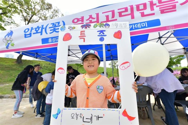 홍성 어린이날 행사에 참여한 한 어린이가 '특종'이라고 적힌 보드를 들고 사진을 찍고 있다. 이날 홍성은 낮기온 25도로 초여름 날씨를 보였으며 (초)미세먼지는 나쁨단계를 보이고 있다.