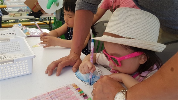 '서산 어린이 가족 한마당 축제'가 열리는 서산종합운동장 보조경기장에서 한 어린이가 아빠와 그림그리기 체험을 하고 있다.