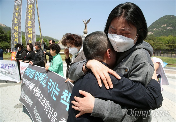 가습기살균제피해자 가족인 박수진씨가 지난 5월 7일 오전 서울 종로구 청와대 앞 분수광장에서 피해자 전신질환 일정과 판정기준 대폭 완화, 피해단계 구분 철폐와 현행 판정 근거 공개 등을 요구하며 삭발하자, 동료 피해자가 박씨를 끌어안고 눈물을 흘리고 있다.