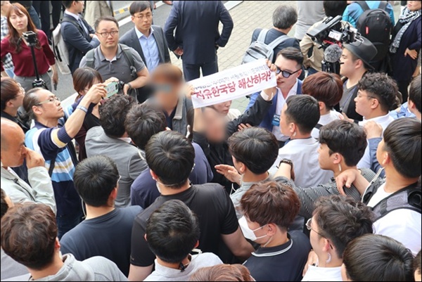 면담을 막아서는 경찰과 자한당 지지자들에게 둘러쌓이자 대학생들이 자유한국당 해산, 황교안 처벌을 요구하고 있다. 