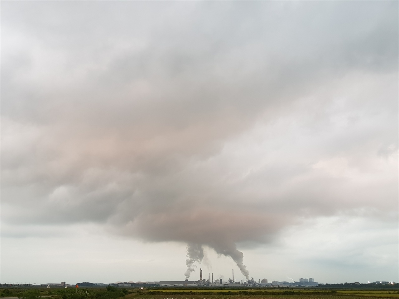현대제철 당진공장에서 배출되는 굴뚝연기가 구름을 이루고 있는 모습. 바람이 덜 한 날이면 이런 모습을 자주 확인할 수 있다.(사진출처 독자제공) 