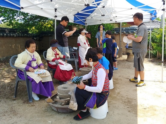 하회마을 노인회관에서 세계유산 활용 프로그램으로 맷돌과 절구질 체험이 이뤄지고 있다. 