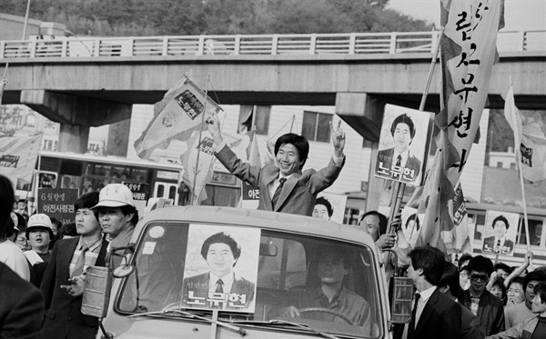 성남국민학교에서 열린 13대 국회의원 부산 동구 선거합동연설회를 마친 노무현 통일민주당 후보가 자동차에 올라 지역구를 돌며 지지를 호소하고 있다. 당시 노무현 통일민주당 후보는 허삼수 민주정의당 후보와의 대결에서 승리해 국회의원으로 당선됐다.