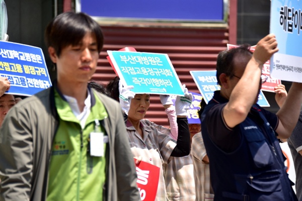 부산대병원에서 일하는 노동자가 "직접고용 정규직화 즉각 이행하라"라고 적힌 손팻말을 들고 기자회견에 참석했다.