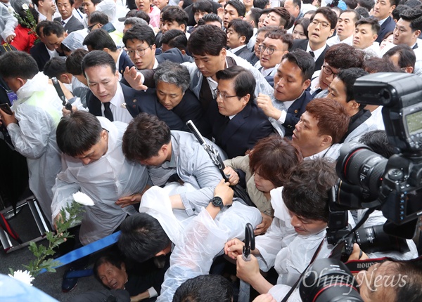 황교안 자유한국당 대표가 18일 오전 광주 북구 국립5·18민주묘지에서 열린 제39주년 5·18민주화운동 기념식에 참석하기 위해 도착하자 일부 시민들이 5?18 망언 의원 징계와 5?18특별법 개정안 처리 등 밀린 숙제를 해결하지 않고 '빈손'으로 재차 광주 방문을 강행한 것에 대해 항의하며 입장을 저지하고 있다. 이 과정에서 쓰러진 시민(왼쪽 아래)이 고통을 호소하는 모습도 보인다. 