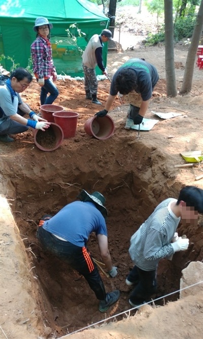 한국전쟁기민간인학살유해발굴공동조사단이 아산시 염치읍 백암리 민간인 희생자 유해발굴 현장에서 유해발굴을 하고 있다.