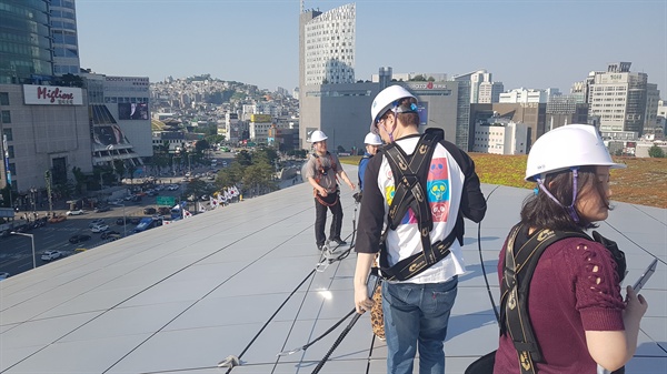 서울디자인재단이 23일 오후 DDP(동대문디자인플라자)의 지붕을 기자들에게 공개했다. 안전모와 함께 고리 달린 등산조끼를 지급 받은 기자들은 천정 중간중간에 있는 철선에 고리를 걸어서 위태위태하게 걸음을 옮겨야 했다.