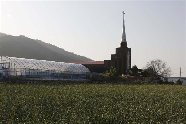 기동마을의 마늘밭과 어우러진 교회. 한낮의 마을풍경이 적막하다.