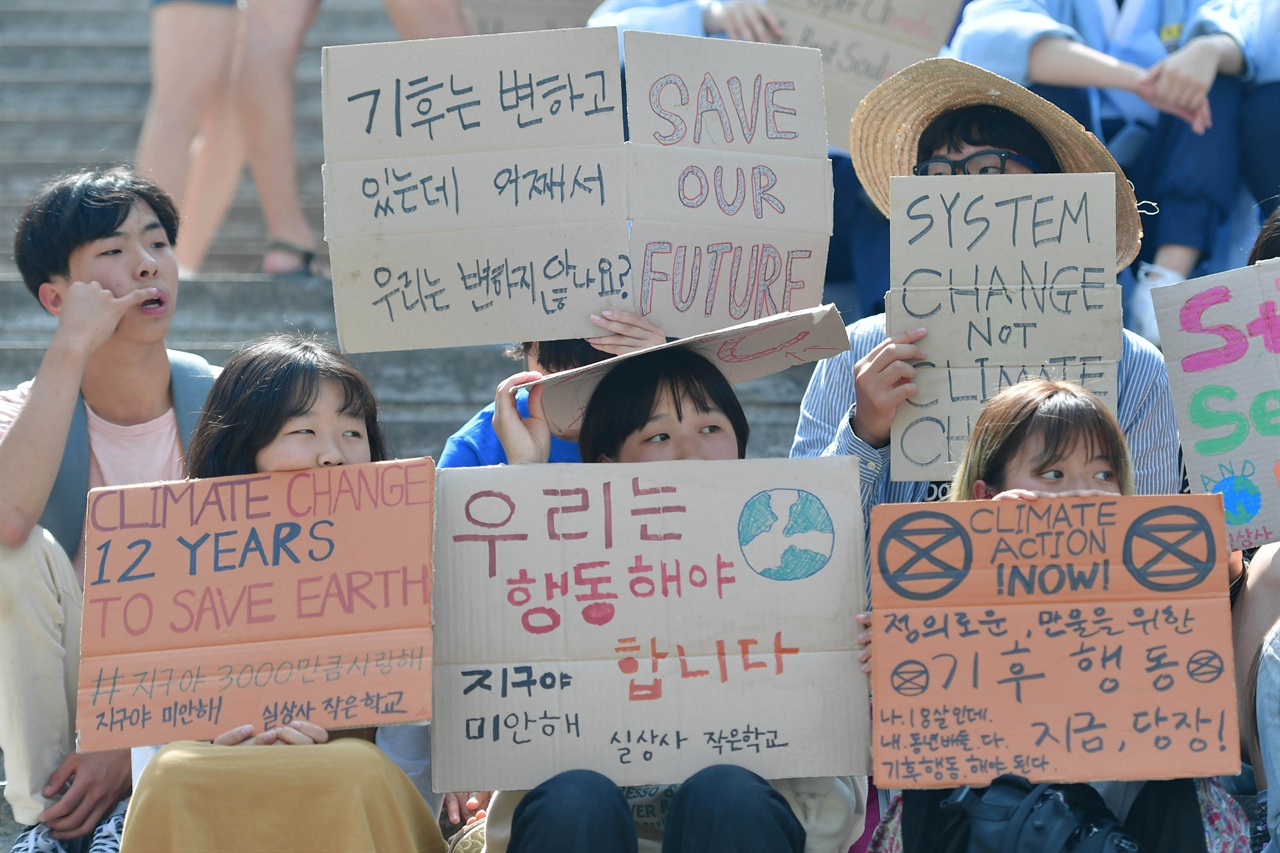 한국청소년기후소송단은 회원들이 24일 오후 서울 종로구 세종문화회관 중앙계단에서는 기후변화에 대해 행동할 것을 요구하는 '524청소년기후변화 해결 촉구 공동행동' 집회에 참가해 손팻말을 들고 있다. 2019.05.24