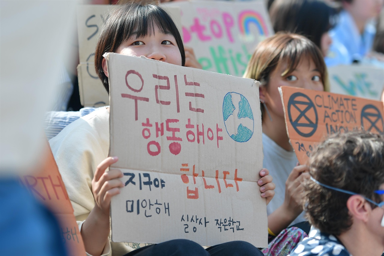 24일 오후 서울 종로구 세종문화회관 중앙계단에서 열린 '524청소년기후변화 해결 촉구 공동행동'에 참여한 한 학생이 "우리는 행동해야 합니다"라고 써진 손팻말을 들고있다. 2019.05.24