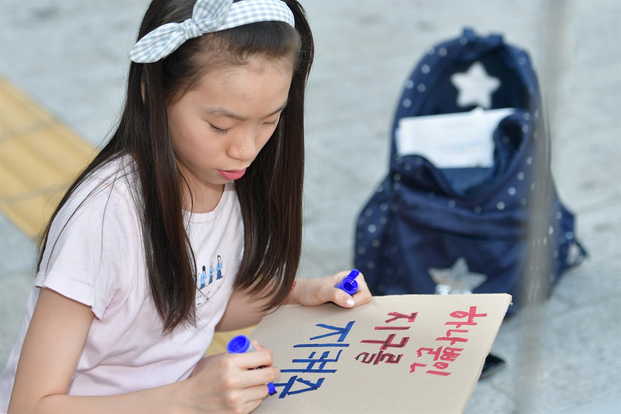  24일 오후 서울 종로구 세종문화회관 중앙계단에서 열린 '524청소년기후변화 해결 촉구 공동행동'에 참여한 한 학생이 "하나뿐인 지구를 지켜주세요"라고 써진 손팻말을 만들고 있다. 2019.05.24