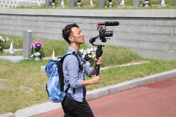  망월동 묘지에서 카메라를 들고 촬영하는 박영이 감독