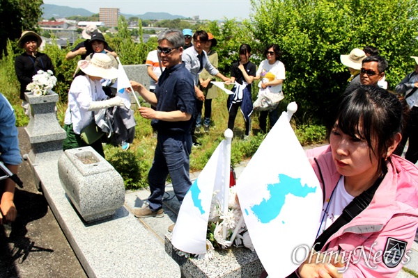 일본 타가와 석탄박물관 뒤편에 있는 '한국인징용희생자위령비'를 찾은 통일촌 회원들이 한반도기를 꽂고 있다.