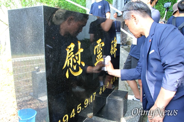 일본 기타큐슈시 오카마쓰의 '오다야마 묘지' 구석에 있는 '조선인조난자위령비'를 박광수 통일촌 대표가 딲고 있다.