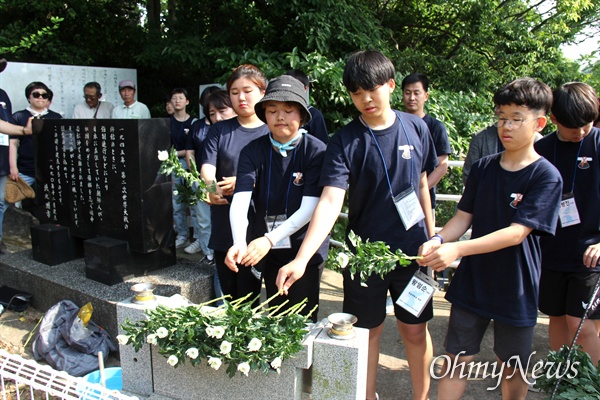 일본 기타큐슈시 오카마쓰의 '오다야마 묘지' 구석에 있는 '조선인조난자위령비'를 찾은 통일촌 회원들이 헌화를 하고 있다.