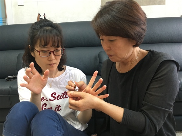 딸 한혜경씨의 손에 연고를 발라주는 엄마 김시녀씨의 모습. 