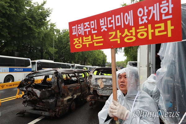 속초 산불피해자 및 고성 상공인 비상대책위원회 회원들이 7일 오전 청와대 부근인 종로구 효자치안센터앞에서 불에 탄 차 2대를 가지고 와서 지난 4월 발생한 산불피해 보상 촉구 집회를 개최했다.