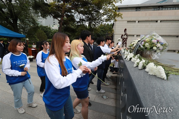 이한열 열사 32주기 추모식이 첫 학교 공식행사로 열린 7일 오후 서울 서대문구 연세대 한열동산에서 재학생들이 1987년 고인이 경찰 직격최루탄에 피격될 당시 입었던 옷과 같은 옷을 맞춰입고 참석해 헌화하고 있다.